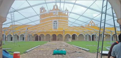  ??  ?? En previsión de que llueva, se instalan grandes toldos en el atrio del convento de Izamal para los invitados a la misa de ordenación episcopal de monseñor Fermín Sosa Rodríguez