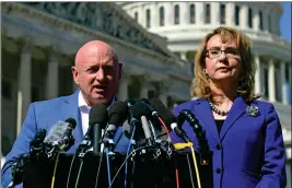  ?? AP PHOTO/SUSAN WALSH, FILE ?? IN THIS OCT. 2, 2017, FILE PHOTO, former Rep. Gabrielle Giffords, D-Ariz., listens as her husband, retired astronaut Mark Kelly, speaks on Capitol Hill in Washington. Kelly entered the race Tuesday to finish John McCain’s term in the U.S. Senate.