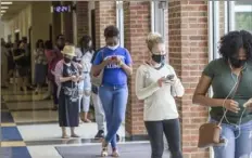  ?? Jenni Girtman/Atlanta Journal-Constituti­on via AP ?? Voters wait in long lines at Peachcrest Elementary School to vote in the primary election Tuesday in Decatur, Ga.