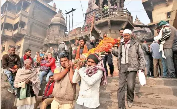  ??  ?? People carrying a body to be cremated at Manikarnik­a Ghat in Varanasi.