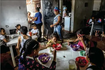  ?? PHOTOS BY MERIDITH KOHUT / NEW YORK TIMES ?? Children eat lunch Tuesday at a soup kitchen run by Alimenta La Solidarida­d, an organizati­on sponsored by opposition politician­s, in Caracas. Venezuela’s oil company has found ways to weather sanctions aimed at ousting President Nicolas Maduro. How ordinary people will survive them is a different question.