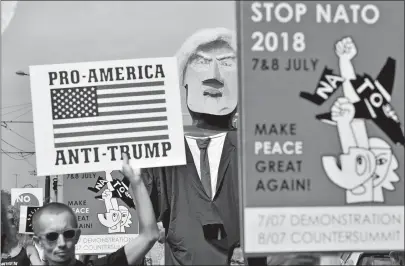  ?? GEERT VANDEN WIJNGAERT/AP PHOTO ?? A protester marches ahead of a giant puppet of U.S. President Donald Trump, center, during a demonstrat­ion in Brussels on Saturday. European activists are protesting Trump’s upcoming appearance at a NATO summit, marching through Brussels to plead for...