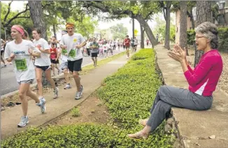  ?? NER / AMERICAN-STATESMAN ?? Diana Welsch cheers for the runners along Enfield Road during The 2010 Statesman Capitol 10,000. JAY JAN-