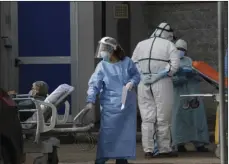  ?? AP PHOTO/GREGORIO BORGIA ?? A paramedic carries a patient outside the first aid area of the Cardarelli hospital in Naples, Italy, Friday. Italian Government and health officials were analyzing data to see if the hard-strapped Campania region, which includes Naples, should be declared a red-zone.