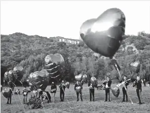  ?? NEW YORK TIMES FILE PHOTO ?? A Mariachi band surrounded by heart-shaped balloons awaits the arrival of a couple’s wedding proposal ceremony Feb. 14, 2022, at Lake Hollywood Park in Los Angeles.