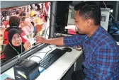  ?? GALIH ADI/JAWA POS ?? DEKATI WARGA: Sukartini menerima e-KTP saat mencetak di Mobil KTP di Festival Pertura kemarin.