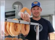  ?? LAUREN HALLIGAN - MEDIANEWS GROUP ?? San Peachey of Peachey’s Baking Company serves a donut at the 2019 Saratoga County Fair.