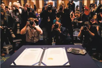  ?? Kent Nishimura / Los Angeles Times ?? Photograph­ers record the articles of impeachmen­t against President Trump before they were signed Wednesday by House Speaker Nancy Pelosi, DSan Francisco, in Washington.