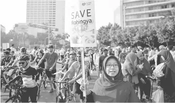  ??  ?? An activist holds a sign during a rally in support of Rohingya minority in Jakarta, Indonesia. — Reuters photo