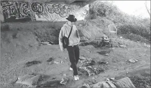  ?? File photo
/ Union Democrat ?? Frank Smart walks through a camp below an overpass during a homeless survey intuolumne County in 2011.