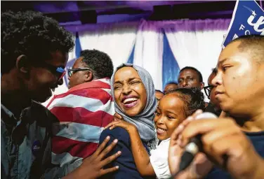  ?? Mark Vancleave / Associated Press ?? Minnesota state Rep. Ilhan Omar celebrates with her children after her victory in the Democratic primary for the 5th Congressio­nal District. No Republican has won the seat in decades.