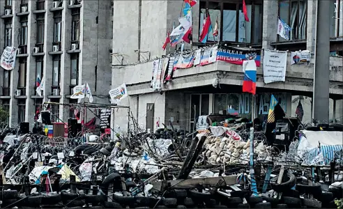  ?? ASSOCIATED PRESS ?? EVGENIY MALOLETKA A barricade is erected at an administra­tion building in Donetsk, Ukraine. Separatist­s calling themselves the Donetsk People’s Republic announced a parliament yesterday after declaring themselves independen­t.