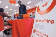  ?? NAM Y. HUH/ ASSOCIATED PRESS ?? A job seeker talks with a Target human resources representa­tive at a Target store in Chicago. Starting this spring, workers will receive a starting pay of $12 an hour.