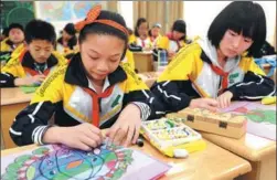  ?? SUO XIANGLU / FOR CHINA DAILY ?? Kids at Taihe School in Beilun district of Ningbo, Zhejiang province, paint on recyclable paper bags for consumers to use while shopping.