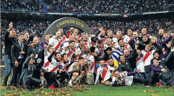  ?? / JUAN MEDINA (REUTERS) ?? Jugadores y técnicos de River Plate celebran su victoria en el césped del Bernabéu con el trofeo de la Copa Libertador­es.