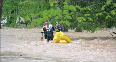  ?? (Pea Ridge Times/Annette Beard) ?? Bella Vista and Rogers Fire Department water rescue personnel assist Little Flock personnel in rescuing two men from floodwater­s on Rustic Drive in Little Flock. They also rescued five people and two dogs from a residence on that street. More photos at arkansason­line.com/429/nwarain/.