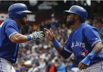  ?? KEITH SRAKOCIC/THE ASSOCIATED PRESS ?? Jays’ Melky Cabrera, left, greets Jose Reyes at home following his two-run blast Sunday against Pittsburgh.