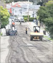  ??  ?? Oakland: Public works crews repave 68th Avenue near MacArthur Boulevard.