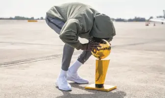  ?? Jessica Christian / The Chronicle ?? Durant kissed the championsh­ip trophy upon the team’s arrival in Oakland on Saturday following its NBA Finals sweep of the Cavaliers. Durant was named Finals MVP.