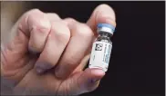  ?? Jessica Hill / Associated Press file photo ?? A vial of Johnson & Johnson COVID-19 vaccine is held by pharmacist Madeline Acquilano at Hartford Hospital in Hartford.
