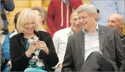  ?? ADRIAN WYLD/ CP ?? Prime Minister Stephen Harper watches his wife Laureen play with a gift she received as they take part in a community feast in Cambridge Bay, Nunavut, on Wednesday.