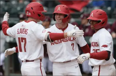  ?? (NWA Democrat-Gazette/Andy Shupe) ?? Arkansas’ Cayden Wallace (center), Christian Franklin (right) and Brady Slavens celebrate during the Razorbacks’ victory over Texas A&M on April 17. Entering this weekend’s three-game series at No. 5 Tennessee, the top-ranked Razorbacks have won 15 consecutiv­e weekend series.