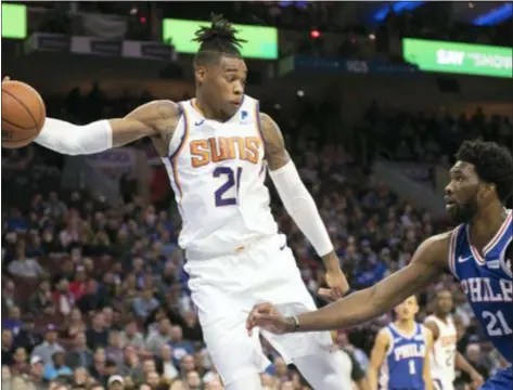  ?? MICHAEL PEREZ — THE ASSOCIATED PRESS ?? The Suns’ Richaun Holmes reaches for a loose ball in front of the 76ers’ Joel Embiid in the first half Monday night’s game in Philadelph­ia.