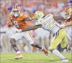  ?? Richard Shiro / Associated Press ?? Clemson’s travis etienne fends off Georgia tech’s Kaleb oliver to gain a first down during the first half their seasonopen­er on thursday. etienne scored on runs of 14, 48 and 90 yards in his big night on the ground for the defending national champions.