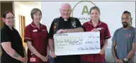  ?? ?? The late Fr. John Kearns, pictured in 2018 with Annmarie and Jason Marshall of the Bikers’ Memorial committee as they presented a cheque to two Friends Of Cancer Care nurses with a cheque from a previous fundraisin­g motorbike run.