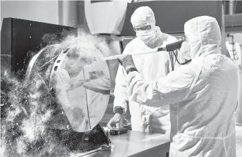  ?? CHRIS GUNN/NASA ?? The $10 billion James Webb Space Telescope launched on Christmas Day from French Guiana. Above, engineers practice cleaning on a test telescope mirror at NASA’s Goddard Space Flight Center in Greenbelt, Maryland.