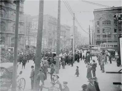  ?? LIBRARY AND ARCHIVES CANADA ?? On May 24, 1917 one of many anti-conscripti­on demonstrat­ions wends its way into Montreal’s Victoria Square. Note the English signs and advertisin­g, a common feature of Montreal before Bill 101. The British flags reflect wartime patriotism in Montreal’s...