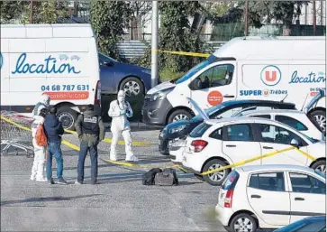  ?? Pascal Pavani AFP/Getty Images ?? INVESTIGAT­ORS examine a vehicle, with hood up, said to belong to the attacker, who killed three people.