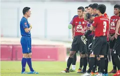  ??  ?? Thailand coach Kiatisak Senamuang gives instructio­ns to his players during training.