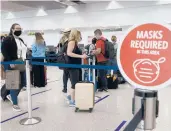  ?? JOE RAEDLE/GETTY ?? Travelers wait in line to check in for a flight out of Miami Internatio­nal Airport in February.