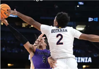  ?? Tribune News Service ?? Above: Furman’s Mike Bothwell (1) fights for the ball with Virginia’s Reece Beekman (2) during the first round of the NCAA tournament in Orlando. Below: Arizona was upset by Princeton Thursday, 59-55.