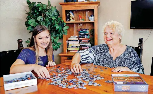  ?? [PHOTOS BY JIM BECKEL, THE OKLAHOMAN] ?? Amber Hyland, public relations and communicat­ions manager for NSO, helps assemble a jigsaw puzzle with “Miss Mickey,” a longtime resident of NSO’s Palo Duro program.