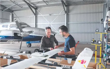 ?? ?? TAKING OFF: Dr Paul Clayton and Daniel Scandar work on a drone at Goondiwind­i.