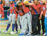  ?? DAVID SANTIAGO/MIAMI HERALD ?? Edwin Diaz is helped by pitching coach Ricky Bones and staff after Wednesday’s game against the Dominican Republic in Miami.