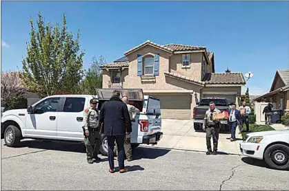  ?? CLAUDIA ELLIOTT / FOR TEHACHAPI NEWS ?? Kern County sheriff’s deputies and investigat­ors exit the home of county Supervisor Zack Scrivner on April 24 with bags and boxes they loaded into a canopied truck.