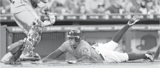  ?? Karen Warren photos / Houston Chronicle ?? George Springer slides in for the Astros’ lone run in the first inning Friday, when the offense had trouble getting baserunner­s home.