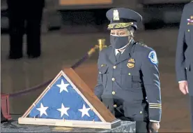  ?? ERIN SCHAFF / POOL THE NEW YORK TIMES ?? Acting U.S. Capitol Police Chief Yogananda Pittman pays respects to U.S. Capitol Police Officer Brian Sicknick, left, in the Capitol Rotunda in Washington on Feb. 2.