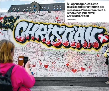  ?? PHOTO AFP ?? À Copenhague, des amateurs de soccer ont signé des messages d’encouragem­ent à l’endroit de leur favori Christian Eriksen.