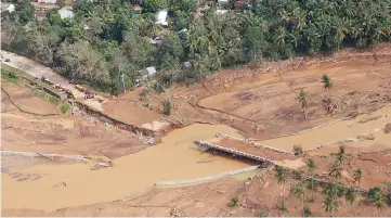  ??  ?? In this photograph taken and released by the Presidenti­al Photo Division (PPD), a bridge damaged after a flash flood brought about by heavy rains, triggered by Tropical Storm Kai-Tak, is seen from the presidenti­al helicopter in Catmon town, Biliran...