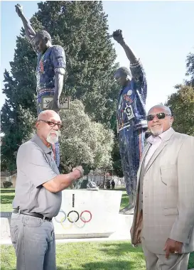  ?? AP ?? John Carlos (left) and Tommie Smith pose Wednesday in front of a statue at San Jose State University that honors their iconic protest at the 1968 Summer Olympics.