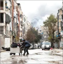  ?? KARAM AL-MASRI/AFP ?? Smoke billows in the background after an explosion yesterday in a rebel-held neighbourh­ood of Aleppo.