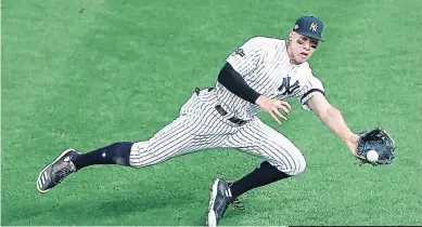  ??  ?? Aaron Judge, de los New York Yankees, se lanza para atrapar la pelota durante el juego 2.