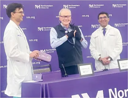  ?? KAITLIN WASHBURN/SUN-TIMES ?? Dr. Gary Gibbon (center) checks his own lungs with a gifted stethoscop­e on Thursday at Northweste­rn Memorial Hospital. Dr. Ankit Bharat (left) and Dr. Satish Nadig performed a combined liver and lung transplant on Gibbon last September.