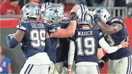  ?? AP ?? Brett Maher is congratula­ted after one of his extra-point attempts finally finds its mark against the Buccaneers.