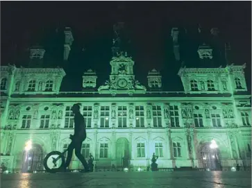  ?? Nadine Achoui-Lesage Associated Press ?? PARIS CITY HALL was illuminate­d in green Thursday after President Trump’s announceme­nt that the United States would withdraw from the Paris climate agreement, which most nations signed last year.