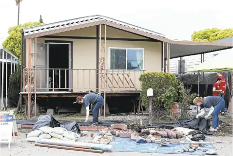  ?? GARY REYES/STAFF ?? Volunteers prepare to install new landscapin­g on a mobile home at the Golden Wheel Mobile Home Park in San Jose on Wednesday. About 150 of the 221 units at the park suffered some sort of damage from the recent floods.